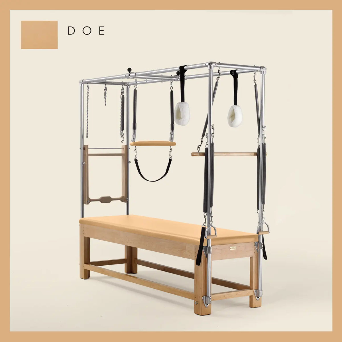 Doe color Pilates Cadillac with maple wood frame, adjustable bars, straps, and springs. Premium Pilates equipment against a beige background.