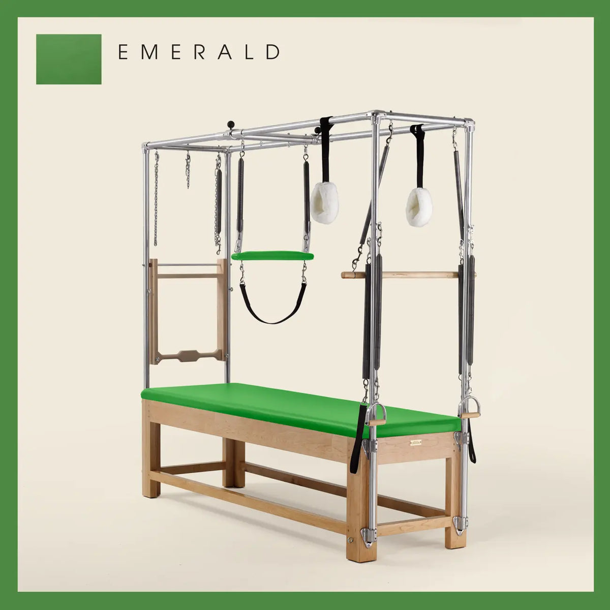 Emerald color Pilates Cadillac with maple wood frame, adjustable bars, straps, and springs. Premium Pilates equipment against a beige background.