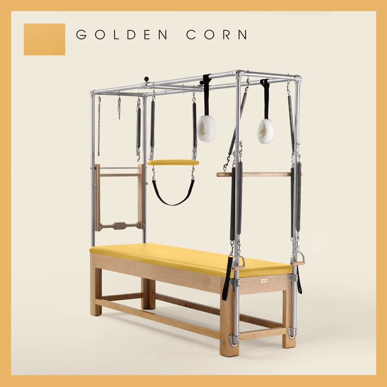 Golden Corn color Pilates Cadillac with maple wood frame, adjustable bars, straps, and springs. Premium Pilates equipment against a beige background.