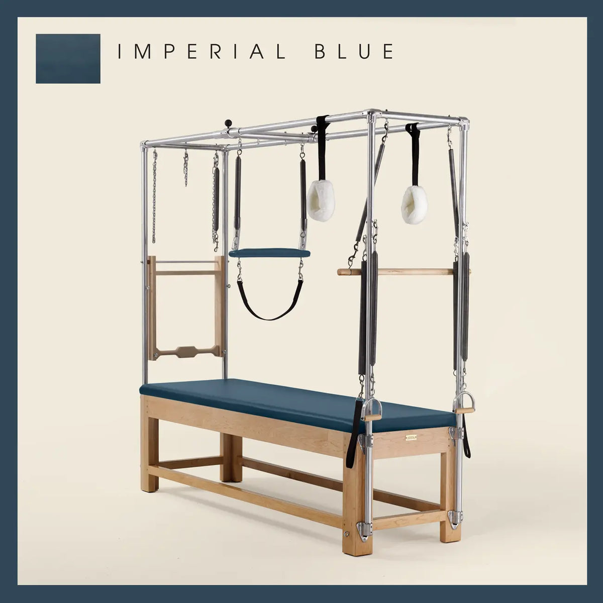Imperial Blue Pilates Cadillac with maple wood frame, adjustable bars, straps, and springs. Premium Pilates equipment against a beige background.