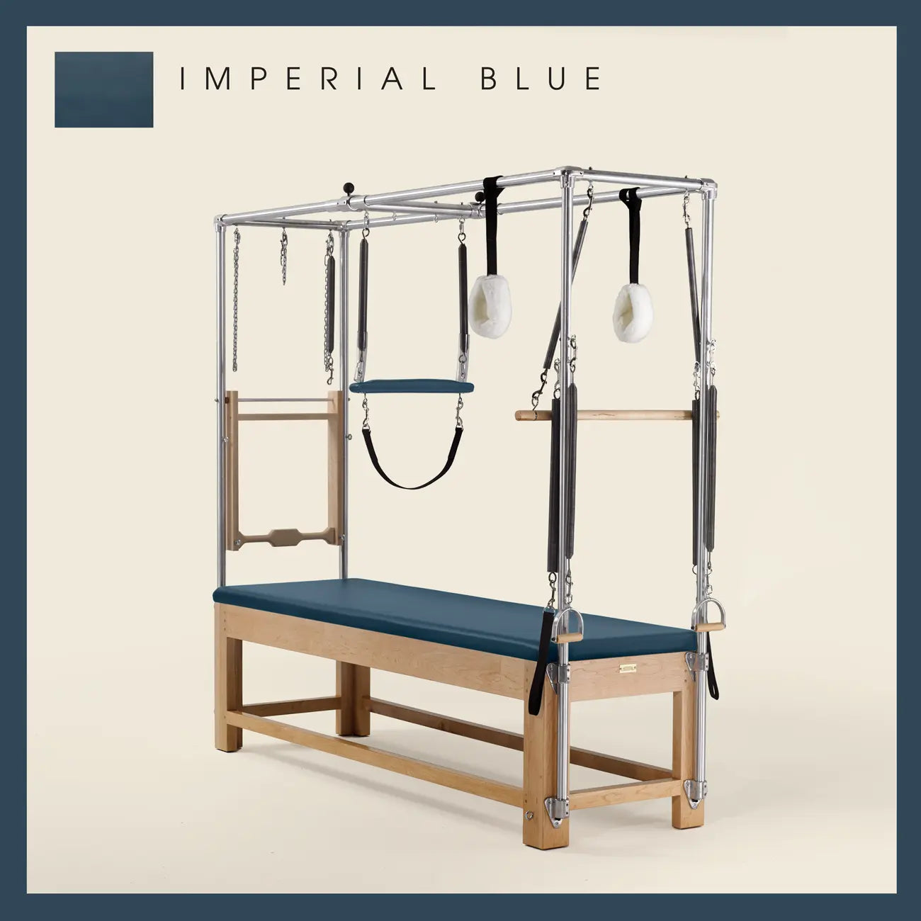 Imperial Blue Pilates Cadillac with maple wood frame, adjustable bars, straps, and springs. Premium Pilates equipment against a beige background.
