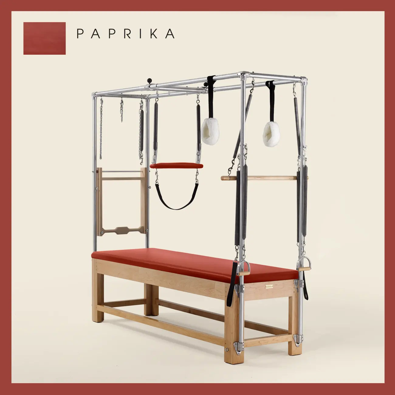 Paprika color Pilates Cadillac with maple wood frame, adjustable bars, straps, and springs. Premium Pilates equipment against a beige background.