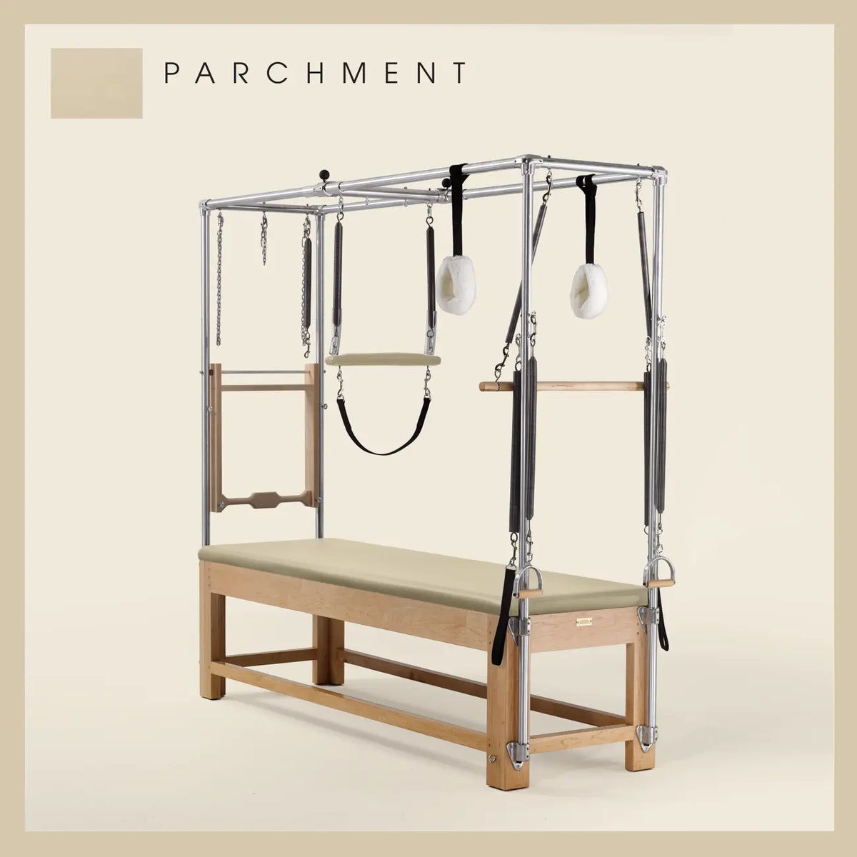 Parchment color Pilates Cadillac with maple wood frame, adjustable bars, straps, and springs. Premium Pilates equipment against a beige background.
