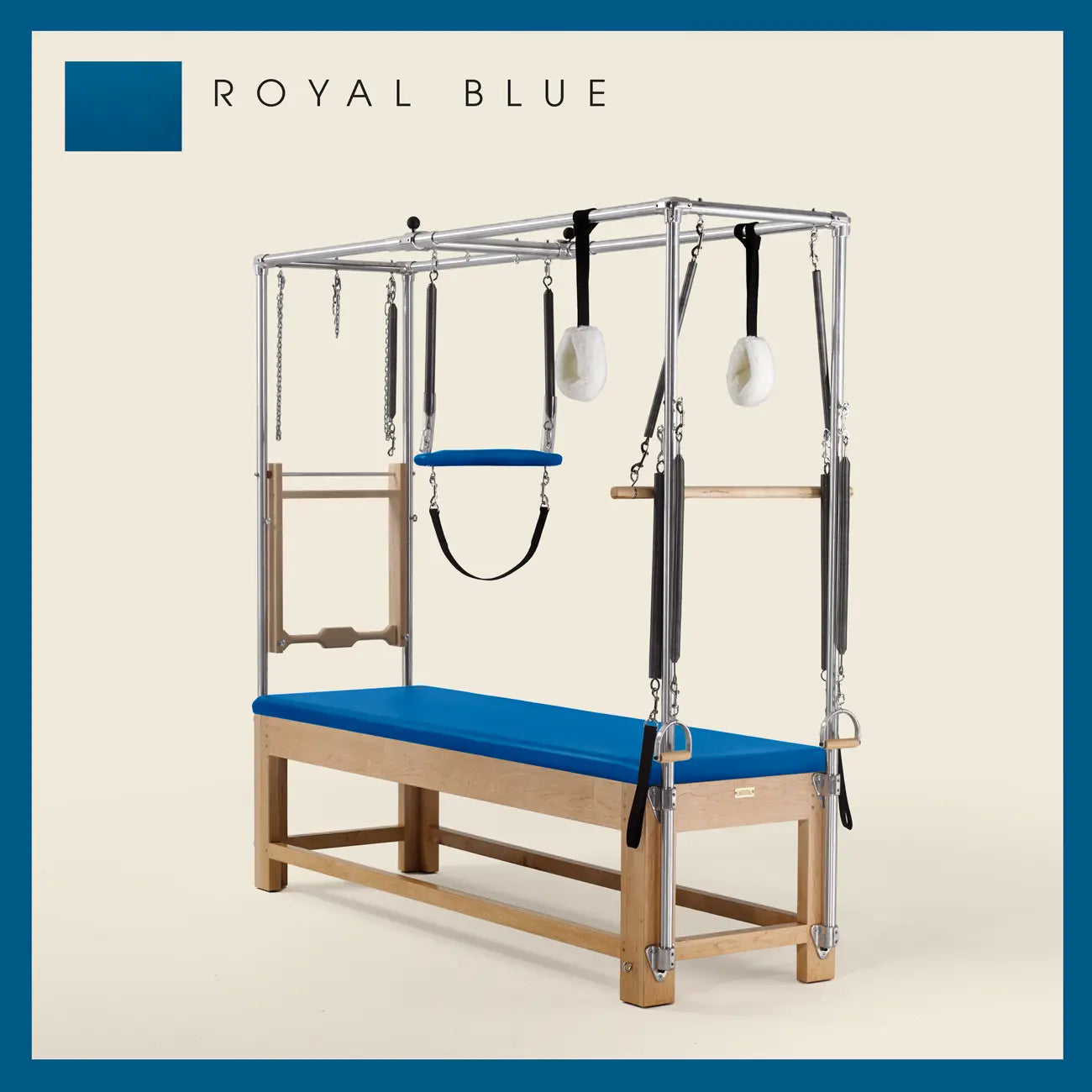 Royal Blue Pilates Cadillac with maple wood frame, adjustable bars, straps, and springs. Premium Pilates equipment against a beige background.