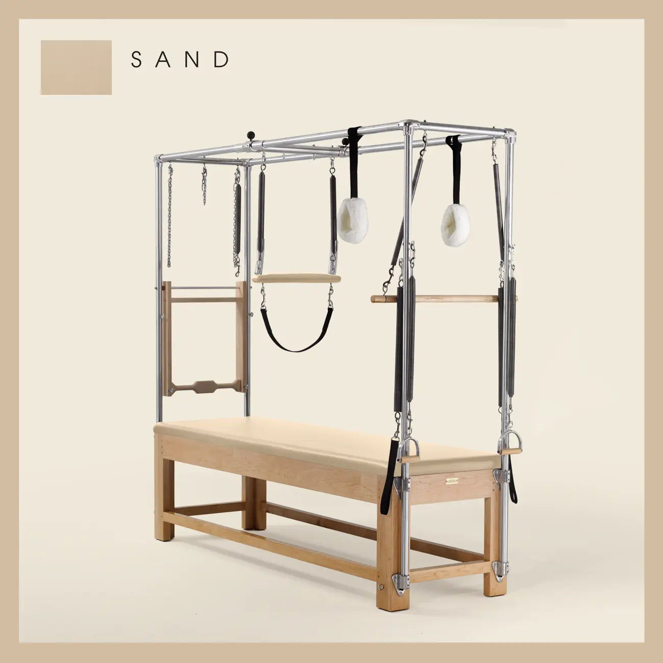 Sand color Pilates Cadillac with maple wood frame, adjustable bars, straps, and springs. Premium Pilates equipment against a beige background.