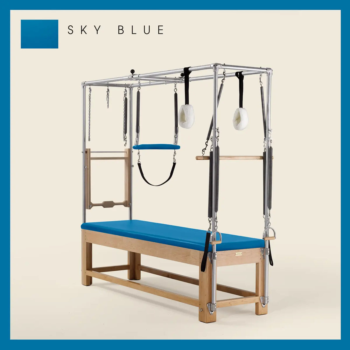 Sky Blue Pilates Cadillac with maple wood frame, adjustable bars, straps, and springs. Premium Pilates equipment against a beige background.