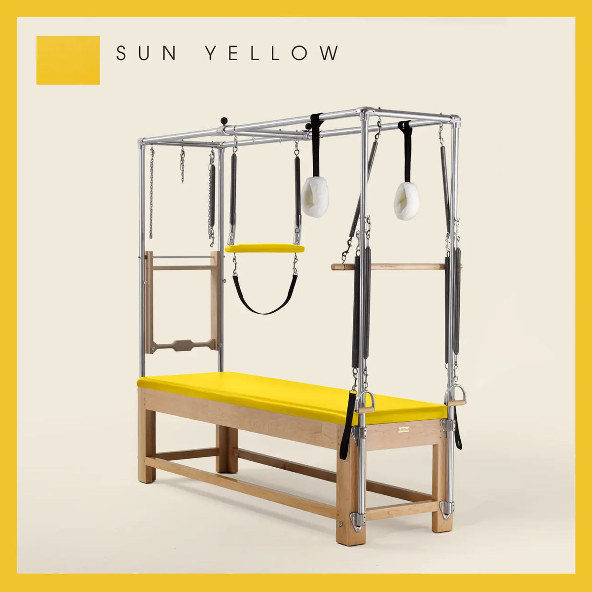 Sun Yellow Pilates Cadillac with maple wood frame, adjustable bars, straps, and springs. Premium Pilates equipment against a beige background.