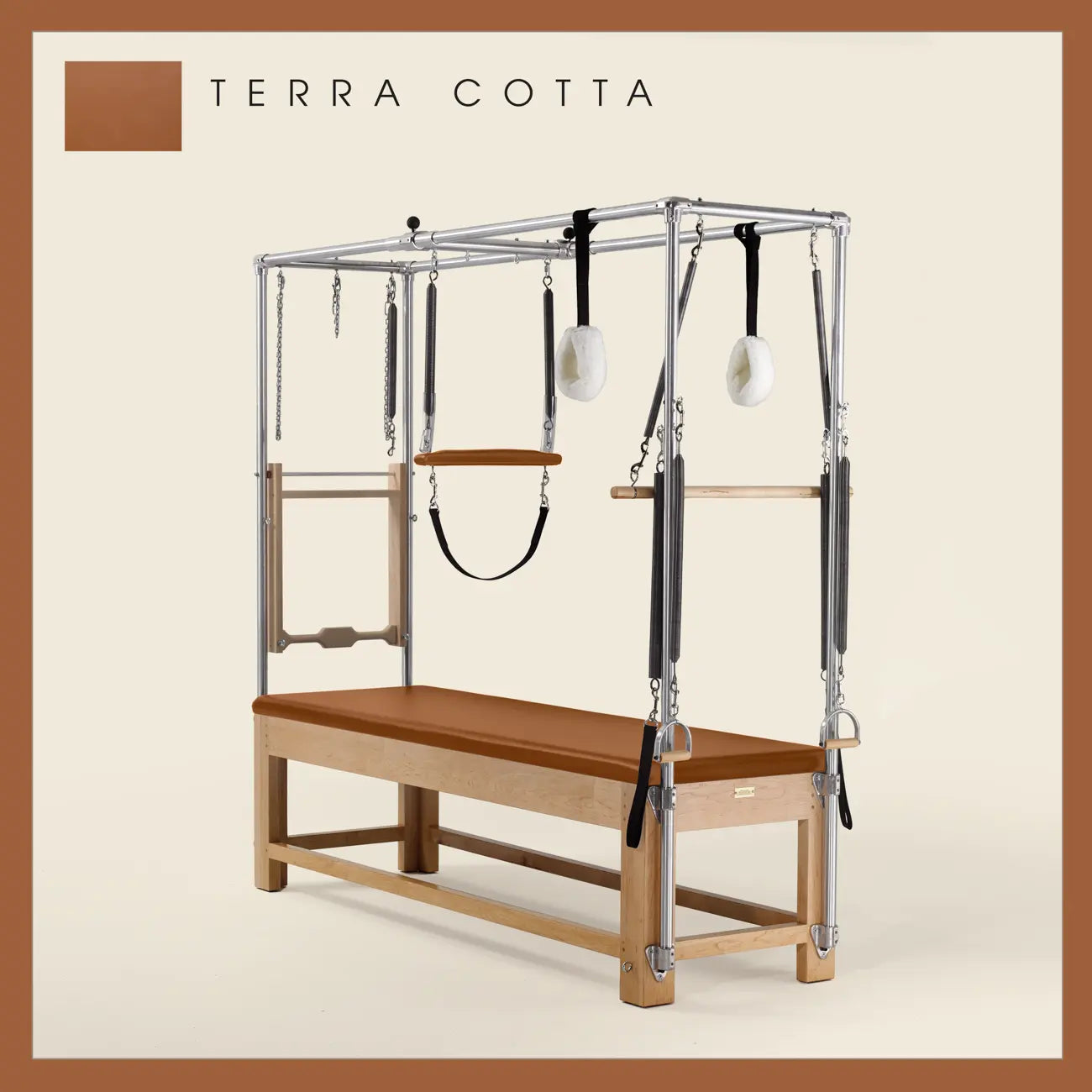 Terra Cotta Pilates Cadillac with maple wood frame, adjustable bars, straps, and springs. Premium Pilates equipment against a beige background.