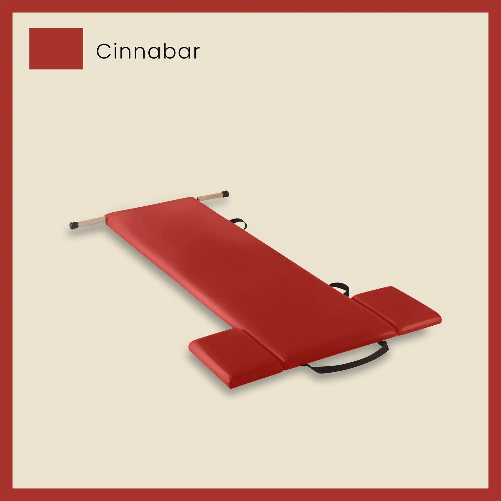 Red pilates mat in cinnabar color with foot strap and side cushions on a neutral beige background.