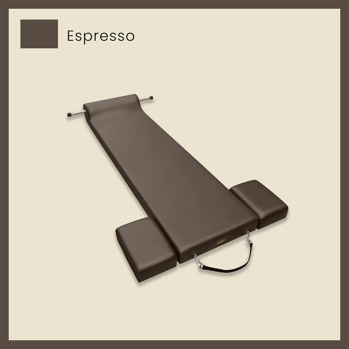 Dark brown pilates mat in espresso color with side cushions and foot strap on a beige background.