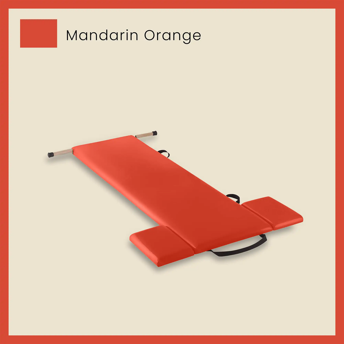 Red pilates mat in mandarin orange color with side cushions and foot strap on a beige background.