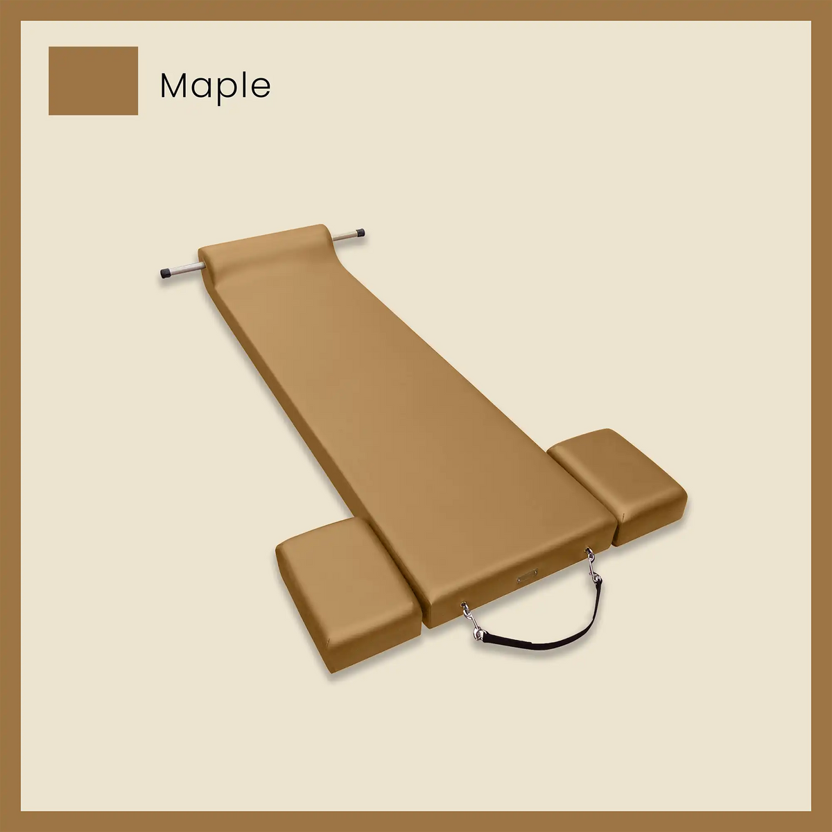 Brown pilates mat with foot strap and side blocks on a light beige background.