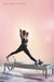 Nicole Smith performs an exercise on a Pilates Reformer in warm pink and yellow lighting. Text reads: "Lead time: 6 months."