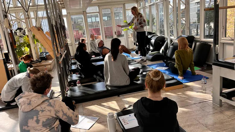 Classical Pilates teacher teaching and educating on Gratz apparatus