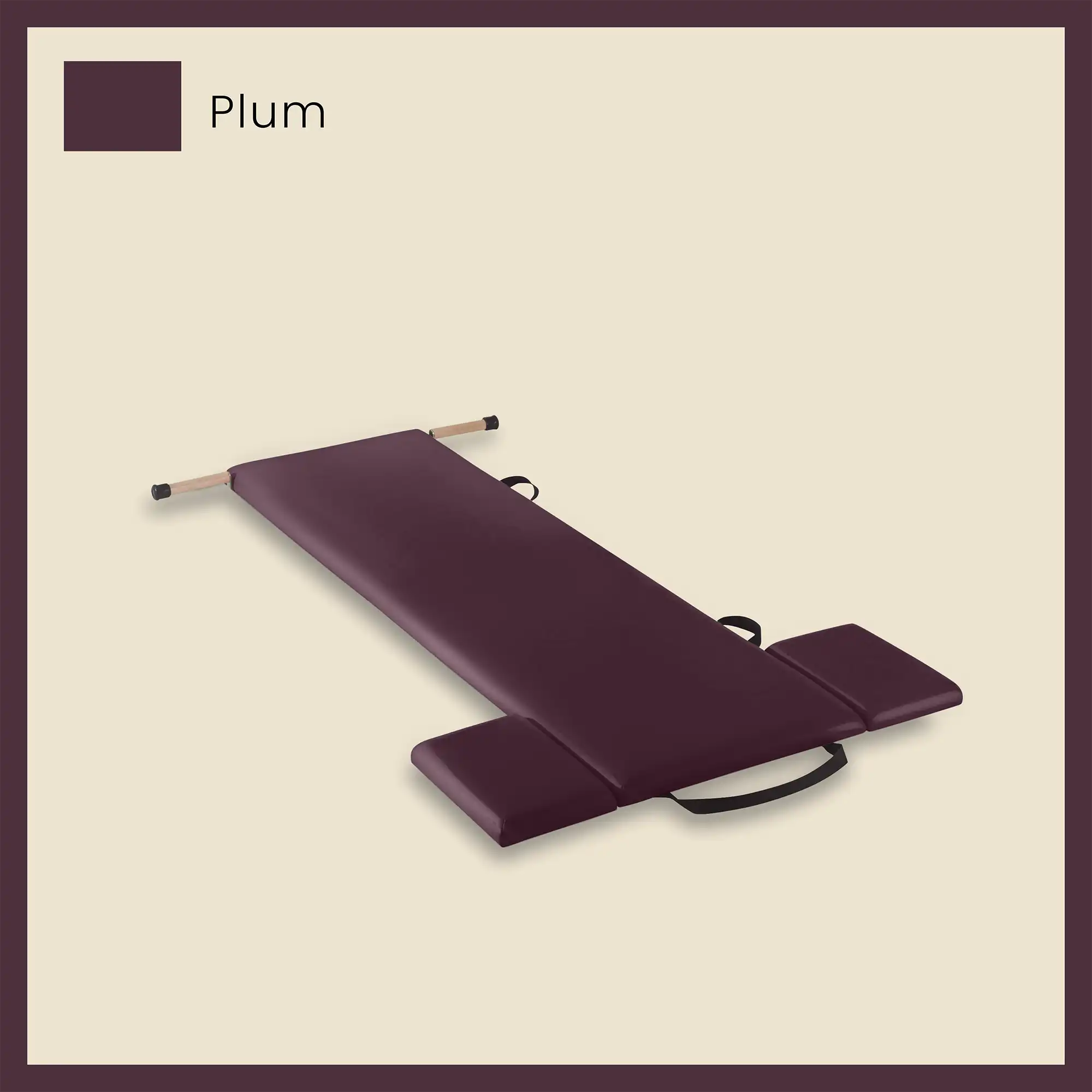 Pilates mat in plum color with side cushions and foot strap on a neutral beige background.