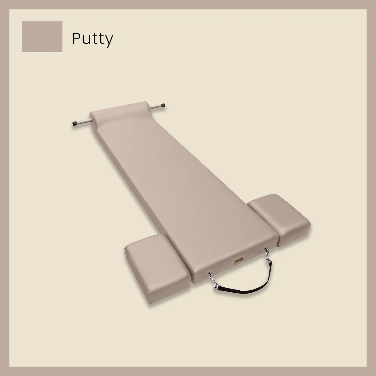 Beige pilates mat featuring side blocks and foot strap on a soft neutral background.