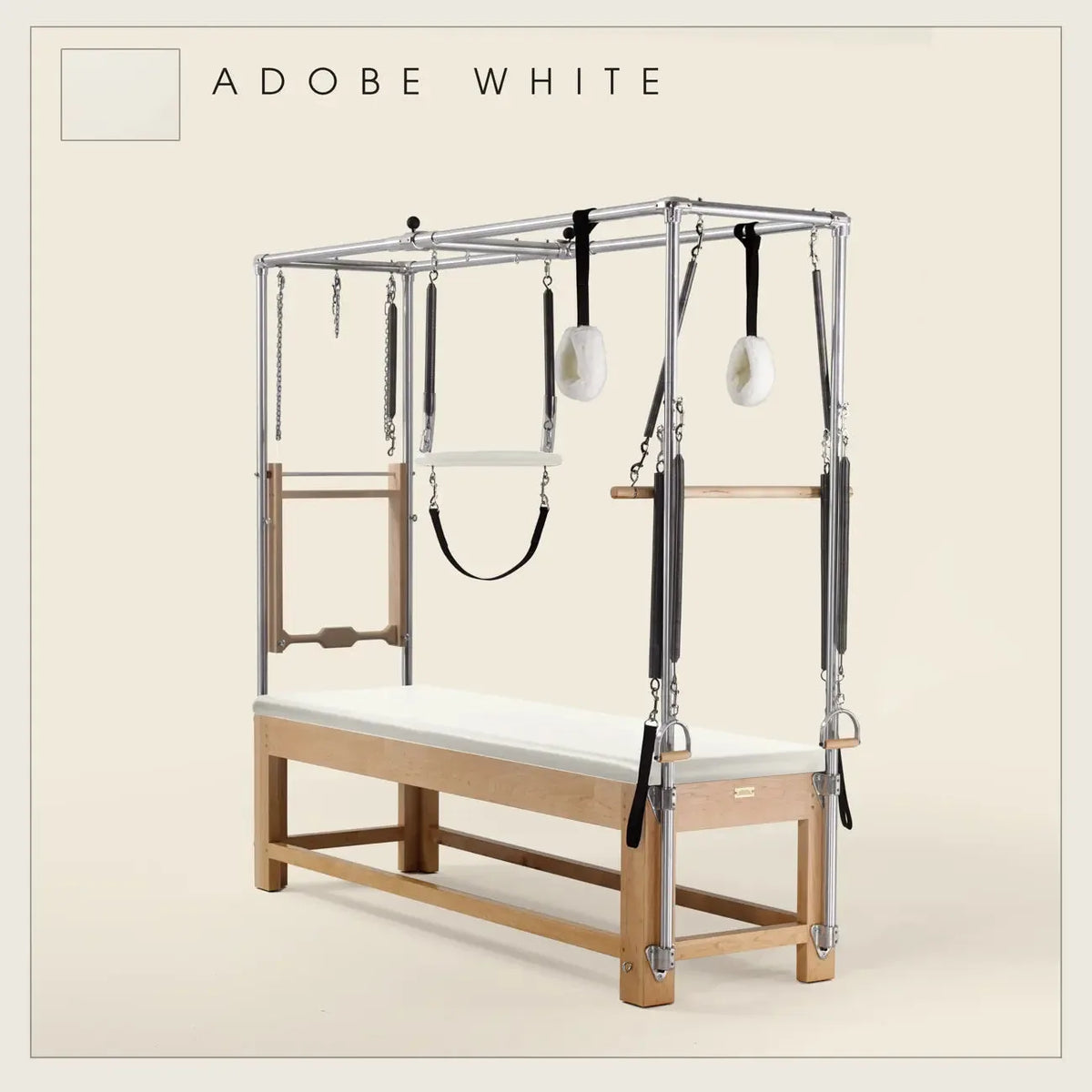 Adobe White ilates Cadillac with maple wood frame, adjustable bars, straps, and springs. Premium Pilates equipment against a beige background.