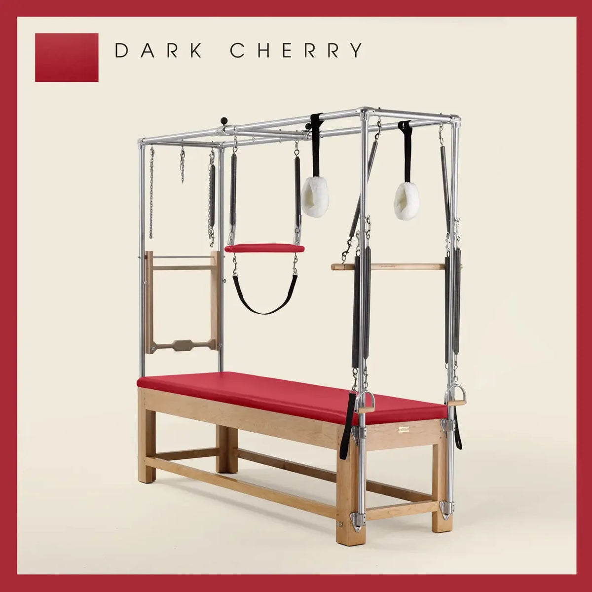 Dark Cherry Pilates Cadillac with maple wood frame, adjustable bars, straps, and springs. Premium Pilates equipment against a beige background.