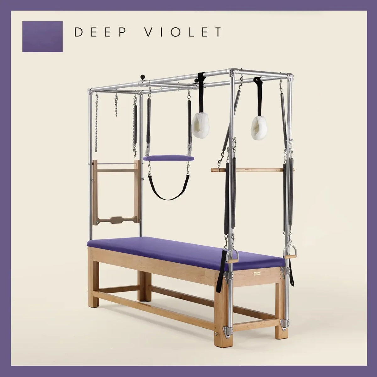 Deep Violet Pilates Cadillac with maple wood frame, adjustable bars, straps, and springs. Premium Pilates equipment against a beige background.