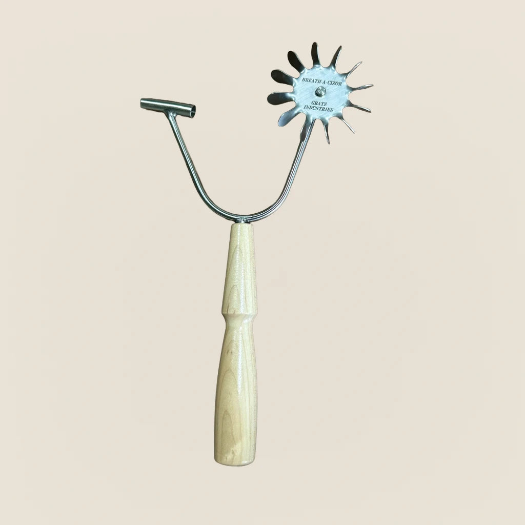 Gratz Breath-A-Cizor Pilates breathing tool with stainless steel spiked wheel and wooden handle.