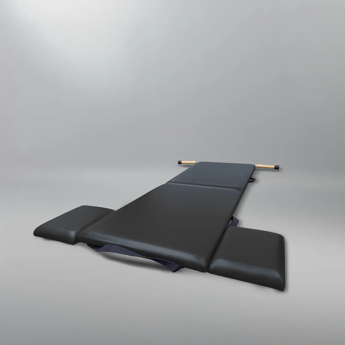 Gratz Pilates folding mat in black with padded sections, wooden dowel, and compact fold design.