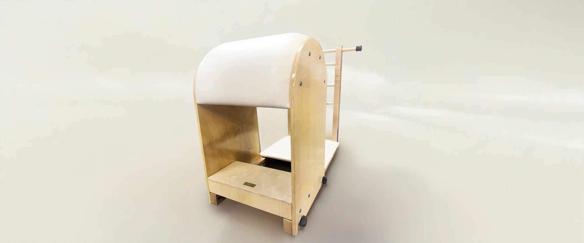 Gratz Pilates Ladder Barrel in Maple Wood in color Ivory sitting behind a creamy background