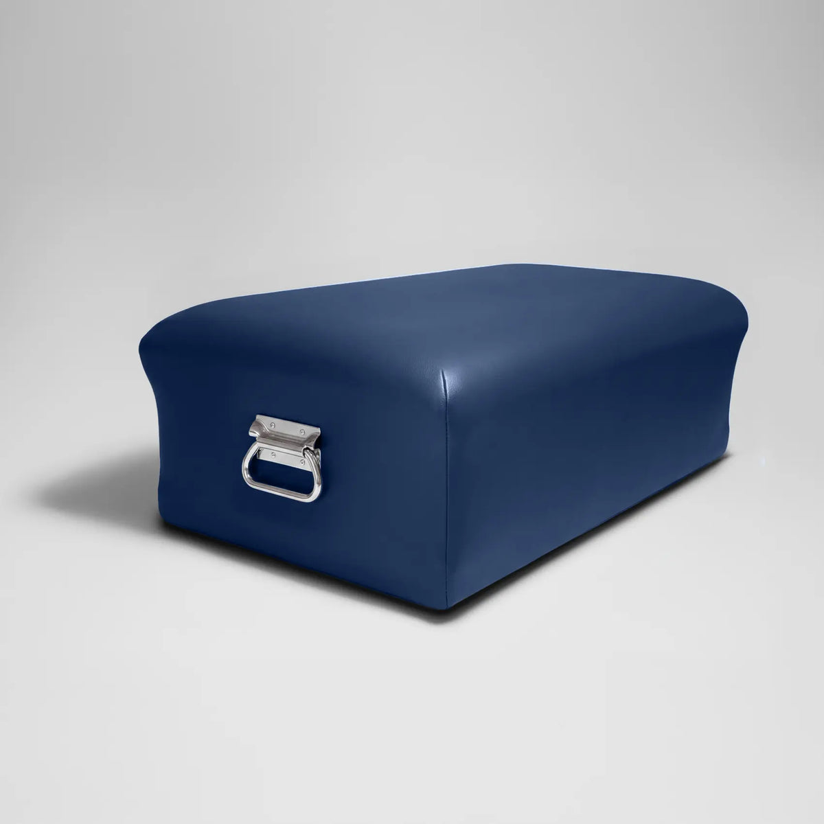 Imperial blue Pilates reformer box with chrome D-ring handle on a light backdrop.