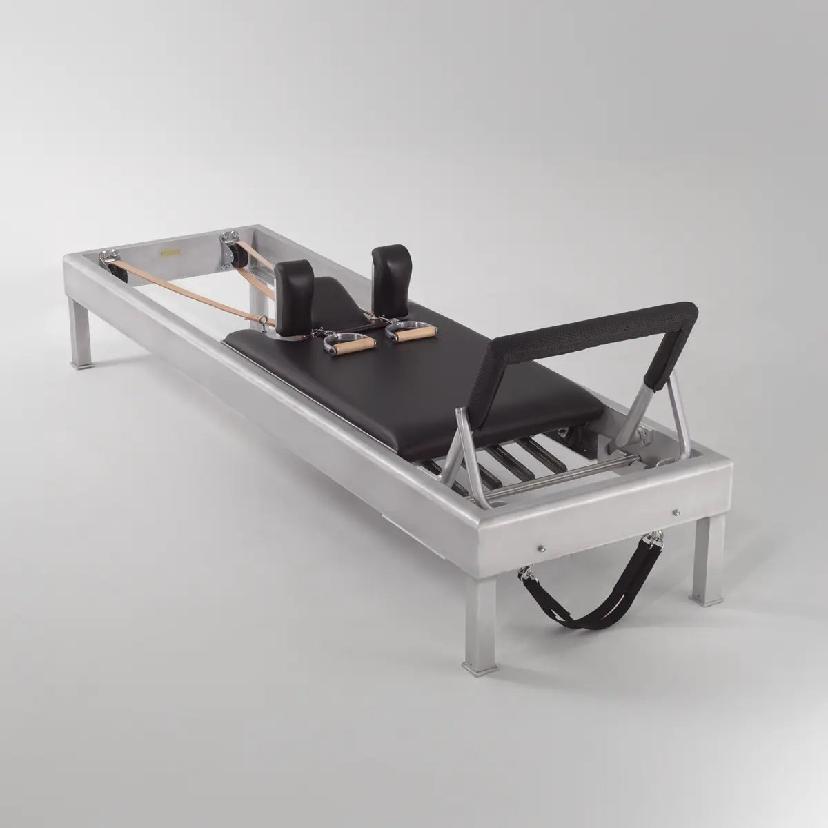 Gratz Pilates reformer with aluminum frame, black leather carriage, shoulder blocks, footbar, and leather straps.