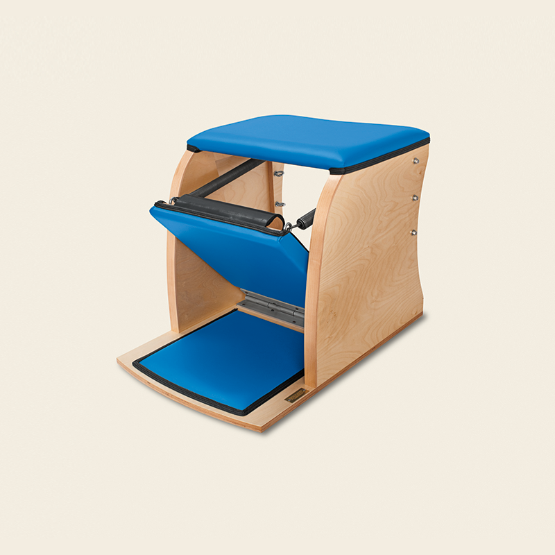Blue Wunda chair with natural wood frame and bright blue cushioning for Pilates exercises.